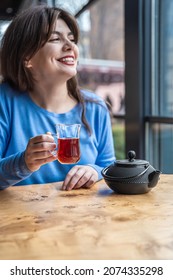 A Young Woman In A Cafe Drinks Turkish Tea.