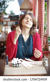 Young Woman In Cafe  Smell Perfume Aroma Oil With Blotter Close Up Photo