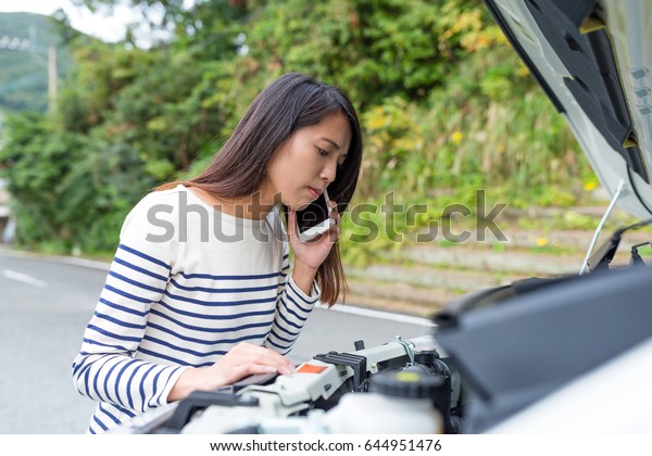 Young Woman\
calling others with repairing the\
car