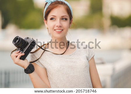 Young woman with camera outdoors portrait. Soft sunny colors. woman with vintage retro camera having fun playful laughing