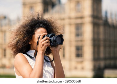 Young woman with camera taking photos in London on Westminster bridge on a sunny day. Filtered image. - Powered by Shutterstock