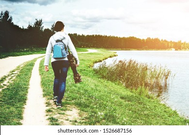 Young Woman With A Camera With A Telephoto Lens, Photographing Birds On The Lake. Wildlife Photographer At Work. Minsk, Belarus.