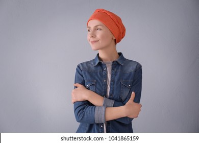 Young Woman With Cancer In Headscarf On Grey Background