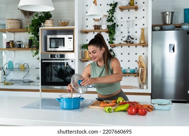 Young Woman Cancer Survivor Cooking And Preparing Vegetarian Meal After Long Heavy Sickness. Vegan Female In The Kitchen Making Healthy Lunch From Fresh Vegetables Changing Way Of Life After Illness.