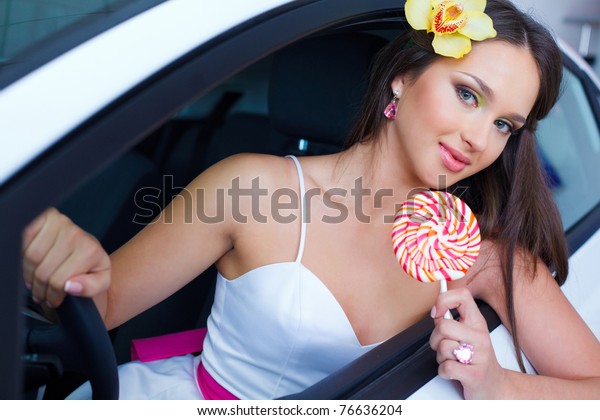 Young woman with candy with\
New car
