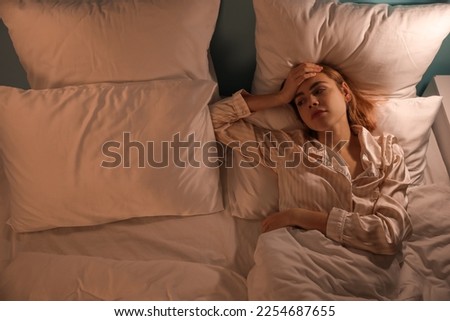 Young woman cannot sleep in bedroom at night