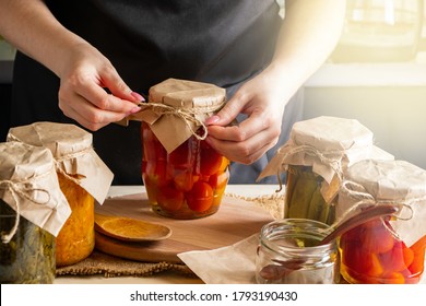 Young woman cans and pickles vegetables. Fermentation process of tomatoes. Healthy eco food. - Shutterstock ID 1793190430