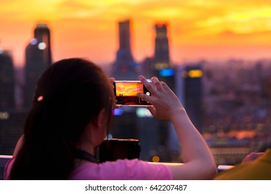 Young woman capture Marina Bay in Singapore at sunset. - Powered by Shutterstock