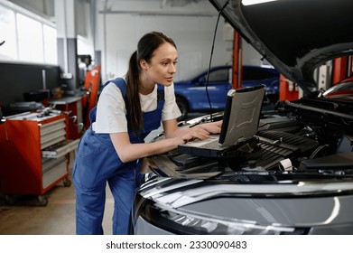 Young woman car engineer providing computer diagnostics - Powered by Shutterstock