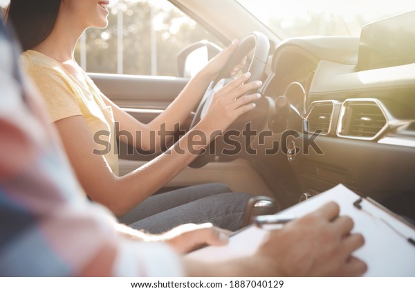 Young woman in car with instructor, closeup.\
Driving school