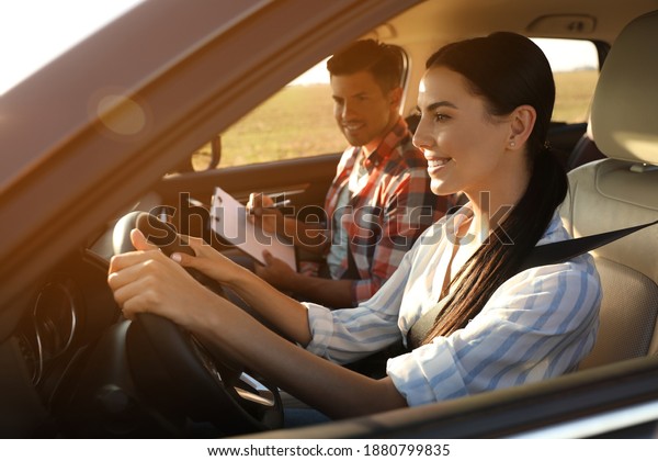 Young woman\
in car with instructor. Driving\
school