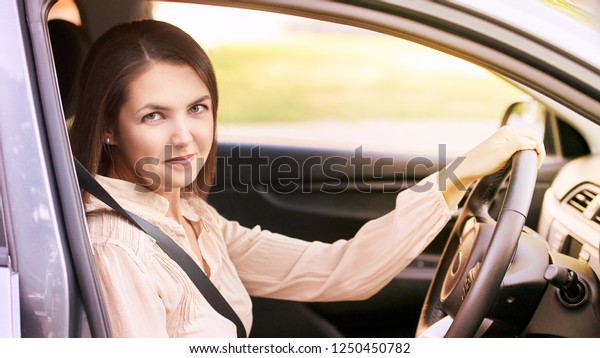 Young\
woman in car. Ride instruction. Automobile\
loan.