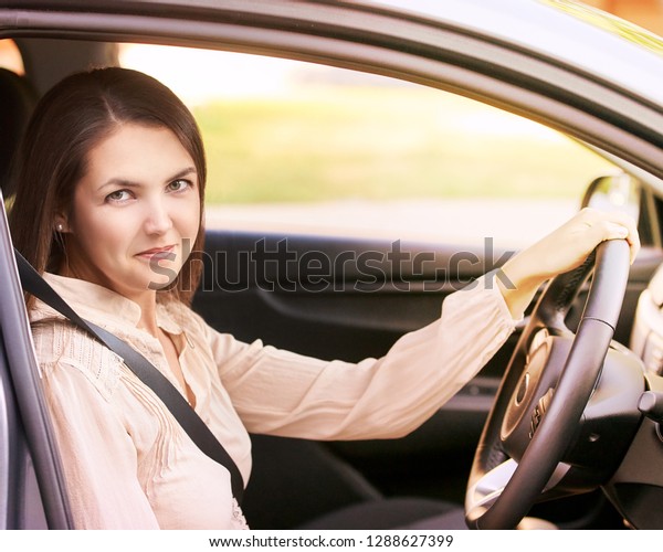 Young\
woman in car. Ride instruction. Automobile\
loan.