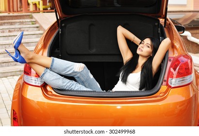 Young woman in the car trunk - Shutterstock ID 302499968