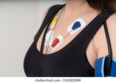 Young woman with cardio monitor, study of the work of the heart, cardiology. Holter monitor. Medical diagnostics. Health care, hospital. ECG sensors - electrocardiogram and blood pressure measurement.