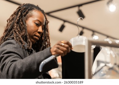 Young woman carefully selecting clothing in a retail store