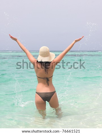young woman in caribbean sea with open hands