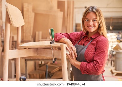Young woman as a carpenter apprentice gluing chair in the cabinet making