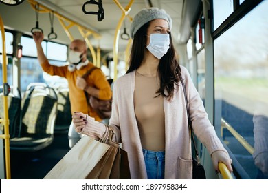 Young Woman Carrying Shopping Bags And Wearing Protective Face Mask While Traveling By Public Transport. 