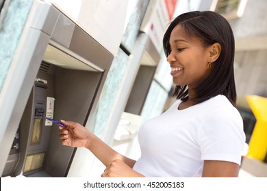 Young Woman At The Cash Machine Withdrawing Money