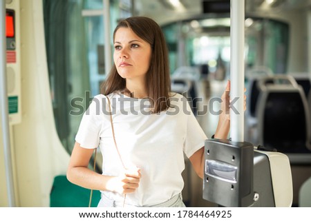 Young woman in casual clothing traveling in public transport 