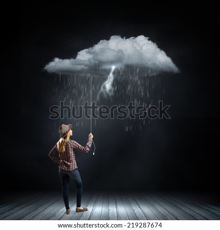 Young woman in casual holding raining cloud on rope
