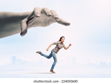 Young Woman In Casual Running Away From Big Hand