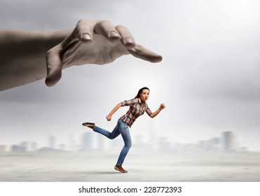 Young Woman In Casual Running Away From Big Hand