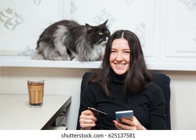 Young Woman And Cat Buy Things Online With Credit Card And Smart Phone. Shopping Concept