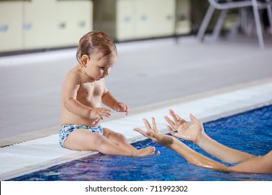 Young woman catching little son sitting poolside in indoor swimming pool
 - Powered by Shutterstock