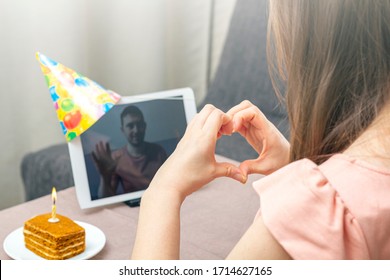 Young woman celebrates birthday during quarantine. Virtual birthday party online with her friend or lover. Video call on tablet. Social distance, stay at home, self-isolation. Selective focus - Powered by Shutterstock