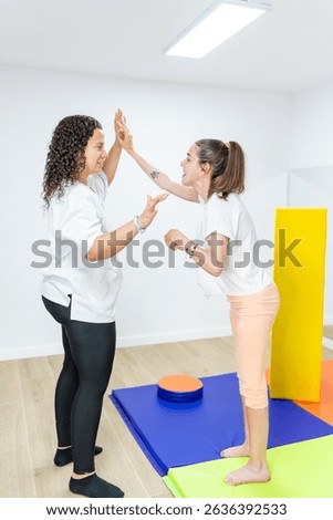 Young Woman with Cerebral Palsy Practicing Stability with Physical Therapist - Practicing balance and stability with support. Concept of cerebral palsy, physiotherapy, stability exercises