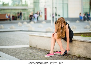 Young Woman Changes Shoes On Street High Heels Instead Of Sneakers