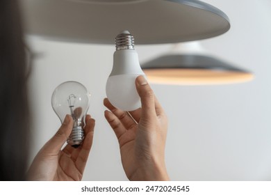 The young woman is changing light bulbs at home - Powered by Shutterstock