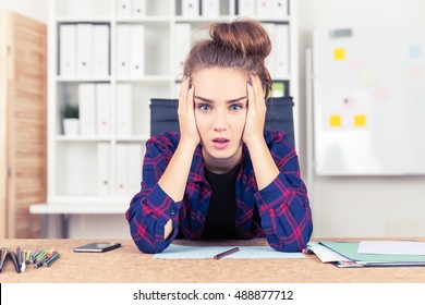 Young woman in checkered shirt is overwhelmed with amount of work she is supposed to do. Concept of overworking - Powered by Shutterstock