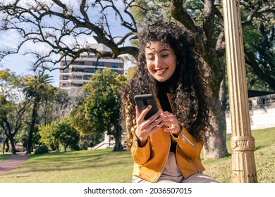 Young Woman Checking Cell Phone Messages In A Public Square. Comunication And Technology Concept.