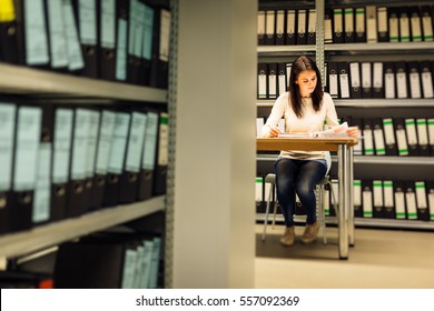 Young Woman Checking Documents In The Archives