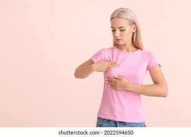 Young woman checking her breast on color background. Cancer awareness concept - Shutterstock ID 2022594650
