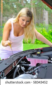 Young Woman Checking Oil Level In The Car