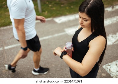 Young Woman Checking Progress On Smart Watch. Female Runner Looking At Smart Watch Heart Rate Monitor