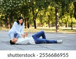 Young woman checking pulse of her husband having heart attack on street