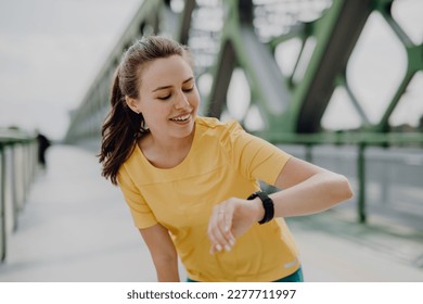 Young woman checking smartwatch in city, preparing for run, healthy lifestyle and sport concept. - Powered by Shutterstock