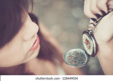 young woman checking time on a pocket watch