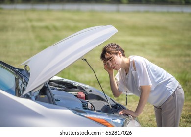 Young Woman Checking Under The Hood.