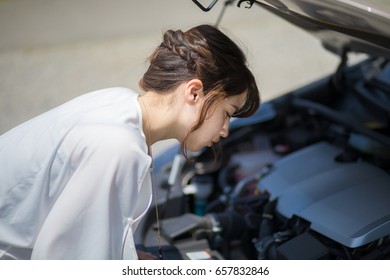 Young Woman Checking Under The Hood.