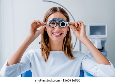 Young woman checking vision with eye test glasses during a medical examination at the ophthalmological office - Powered by Shutterstock