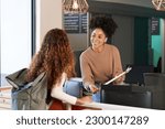 Young woman checks in at front desk, reception, hotel, college library admission