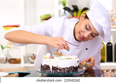 Young Woman Chef Cooking Cake In Kitchen