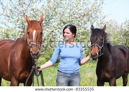 Young woman and chestnut horse with her foal