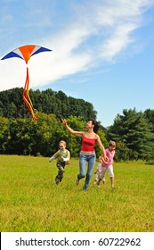 Young Woman And Children Flying A Kite